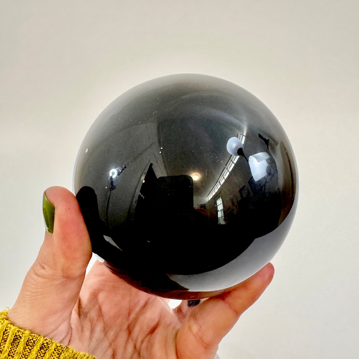 Large black obsidian crystal ball from FoxlarkCrystals, showcasing smooth, polished black obsidian with natural reflective surface.