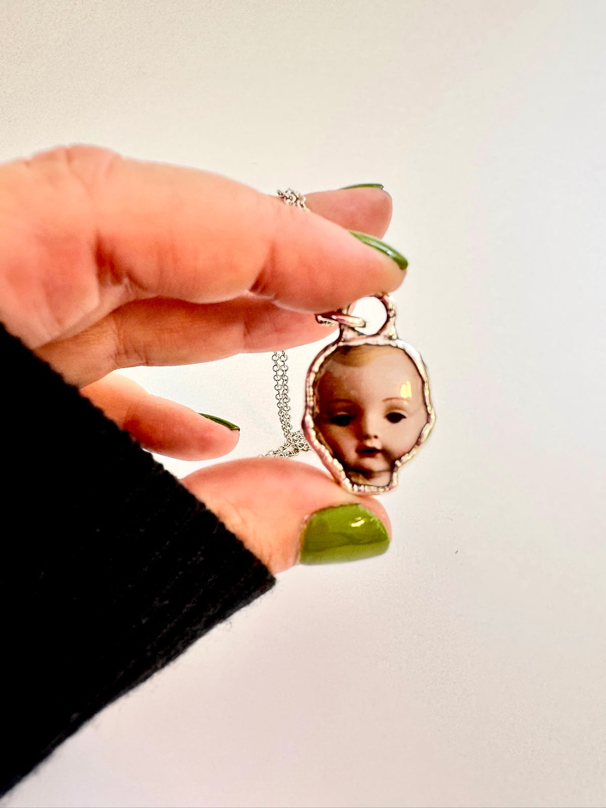 Fine silver doll head necklace from FOXLARK's Weirdlings Collection, featuring detailed craftsmanship and unique design.
