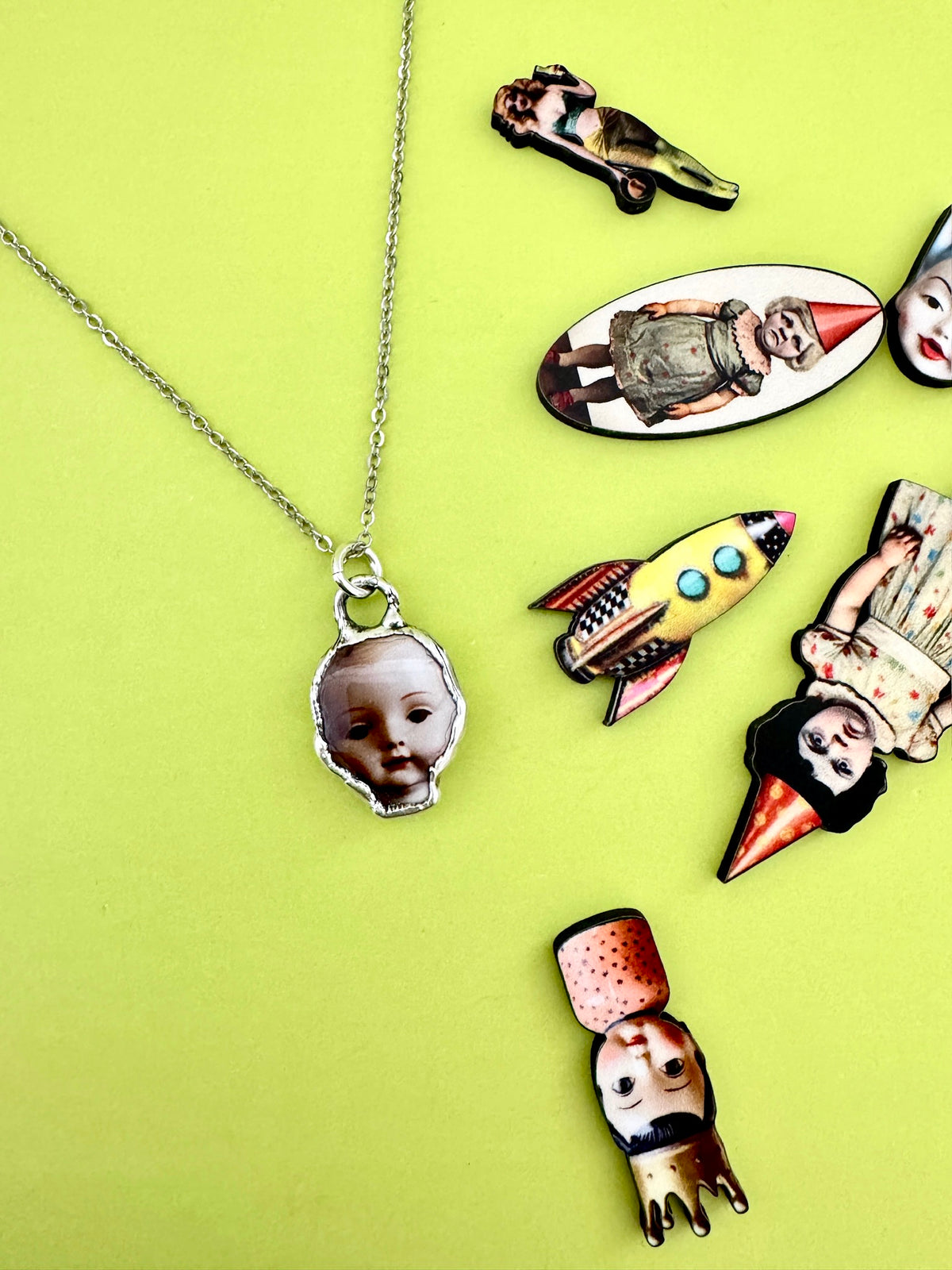 Silver doll head necklace from FOXLARK's Weirdlings Collection, featuring detailed fine silver craftsmanship.
